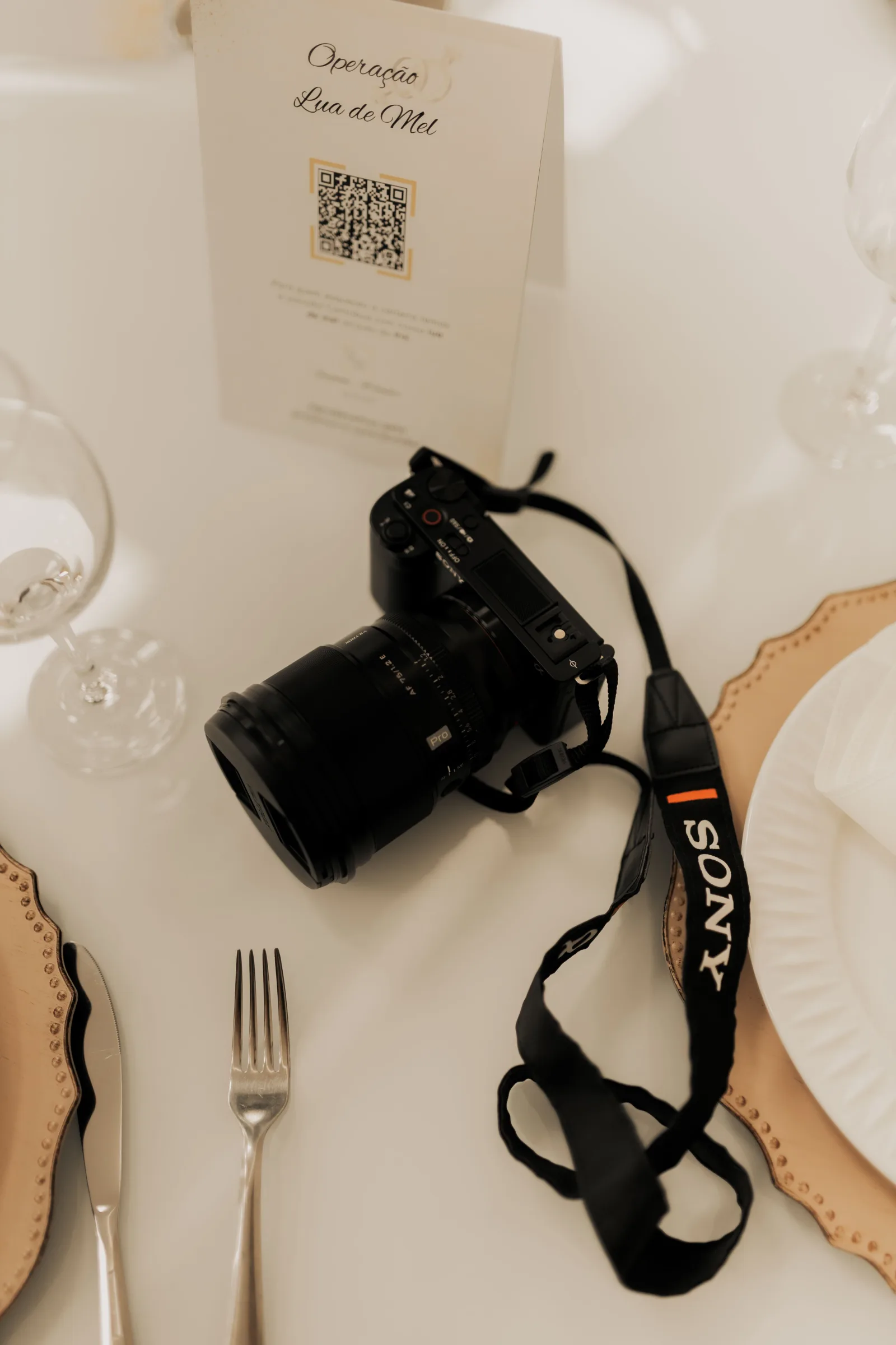 En arrière-plan, des invités souriants à table. — texte alternatif suggéré : Carton d'invitation avec QR code BumFot sur une table de fête